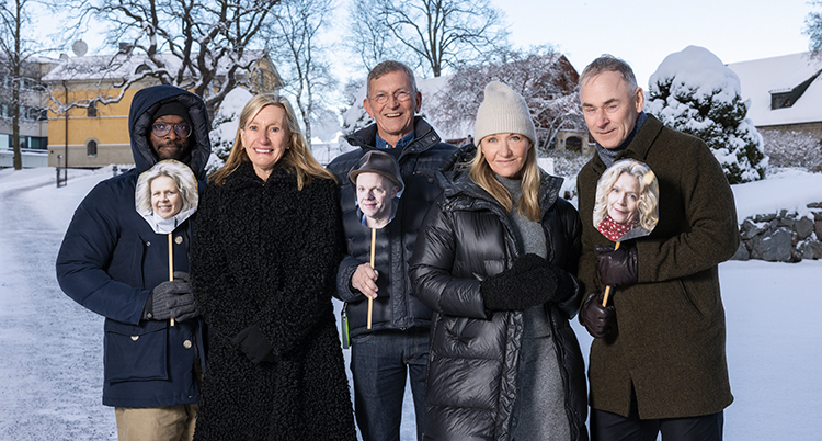 De står utomhus. Det är snöigt. DE har jackor och mössor på sig.