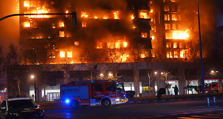 Ett stort hus med lägenheter som brinner.