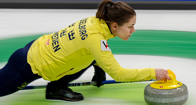 Hon skjuter iväg en sten i curling.