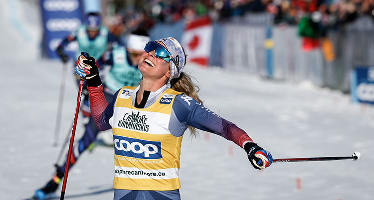 Jessie Diggins går i mål och skrattar.
