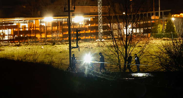 Det är mörkt. Några poliser syns. Starka lampor lyser.