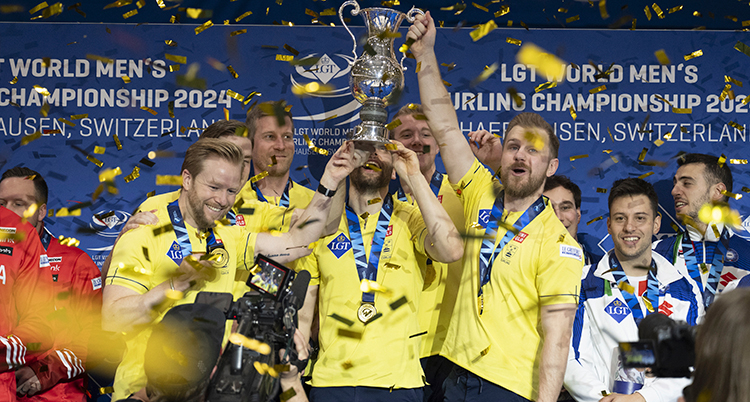 De har gula tröjor. De står i en grupp och håller upp en pokal.