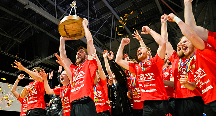 De jublar och sträcker upp armarna. En person lyfter en pokal.