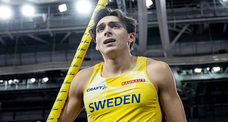 Han håller en stav.