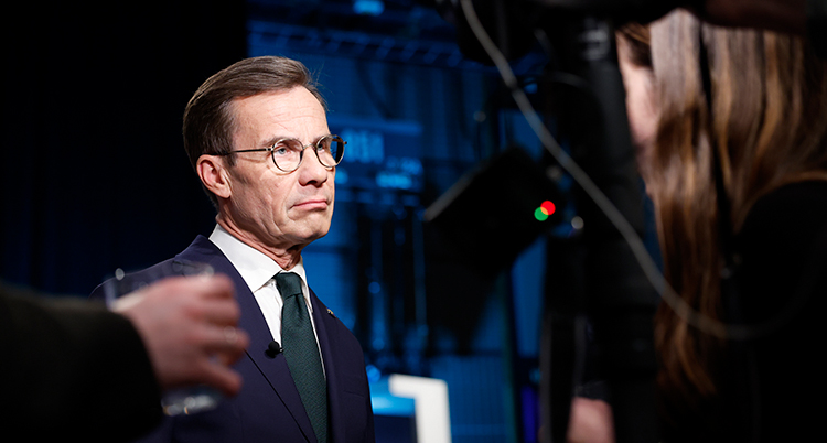 Han har kostym och ser allvarlig ut.