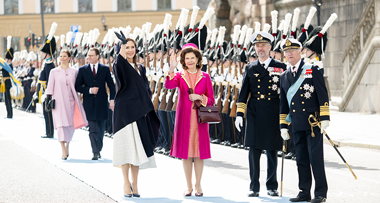 Svenska och danska kungen och drottningen vinkar. Soldater står bakom. Victoria och Danel är på väg fram till dem.