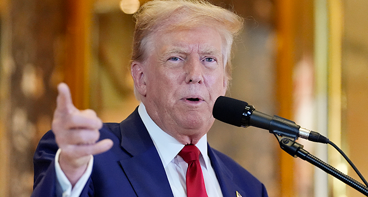 Donald Trump står i kostym och pratar i en mikrofon.