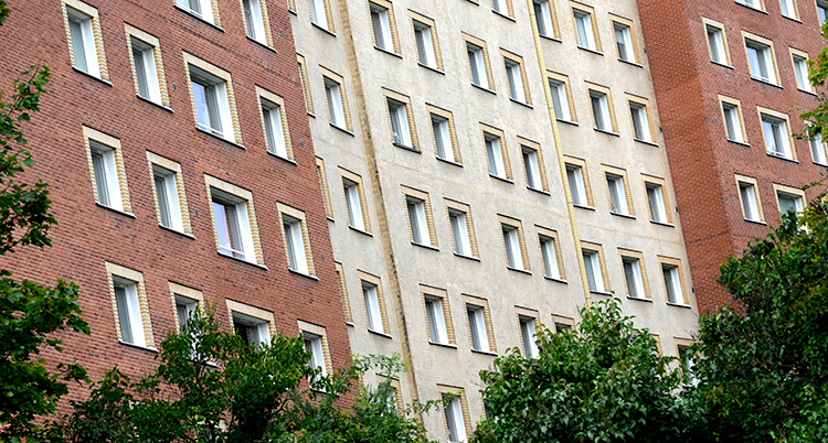 Många fönster på ett stort hus med många lägenheter.