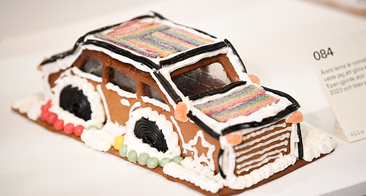 En bil gjord av pepparkaksdeg. Den är dekorerad med vit glasyr och godis.