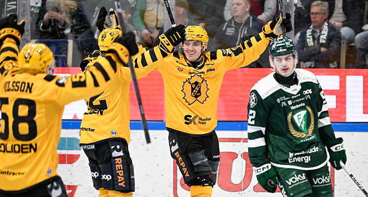 Några spelare i gula tröjor jublar efter ett mål. En spelare i grönt deppar.