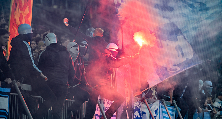 Publik i Malmö har tagit på sig masker och tänt bengaler.