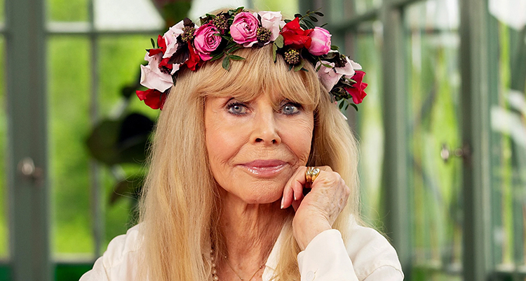Ett porträtt. Hon har en krans av blommor på huvudet.