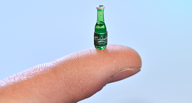 En mycket liten flaska står på ett finger.