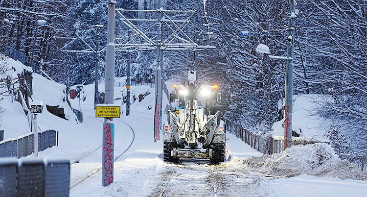 Det är vitt ute av all snö. En traktor står på spåren för spårvagnar.