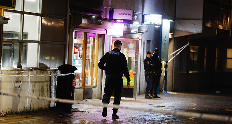 Det är mörkt. Flera poliser är utanför en kiosk.