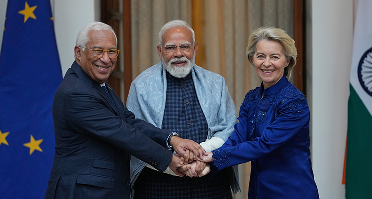 De står framför EUs och Indiens flagga.