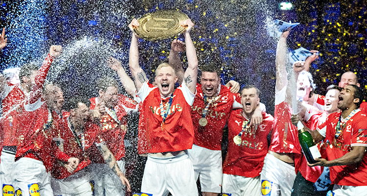 Det danska laget jublar. De sprutar champagne. En av spelarna håller upp priset.