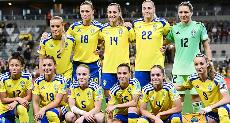 Elva spelare står samlade på planen innan en match. Det är Sveriges landslag i fotboll för damer.