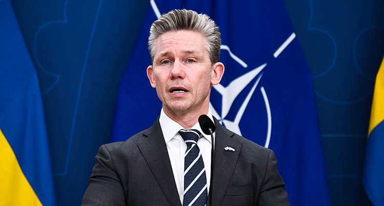 Han pratar i en mikrofon.