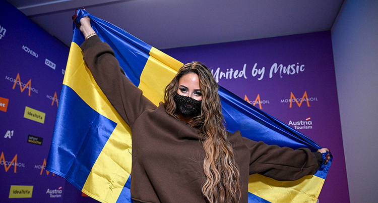 Hon håller upp Sveriges flagga.