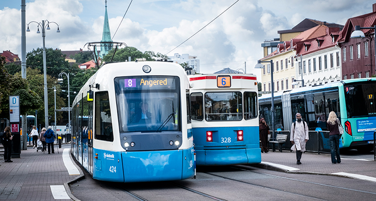 Spårvagnar åker åt varsitt håll. De är mitt i staden.