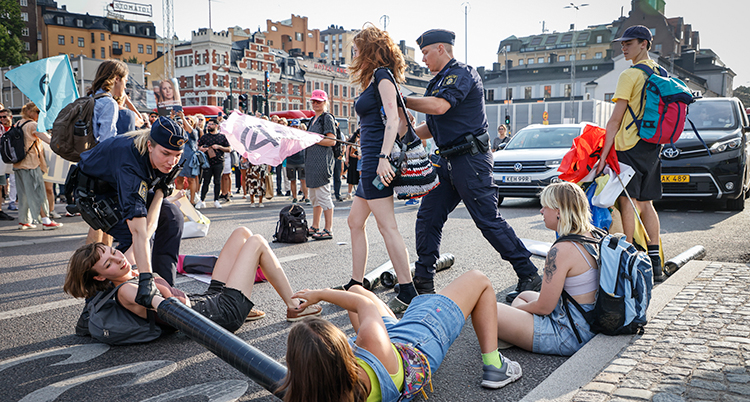 De ligger på vägen. Poliser leder bort dem.