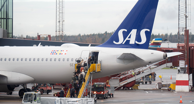 Folk går i en trappa för att komma in i ett flygplan.