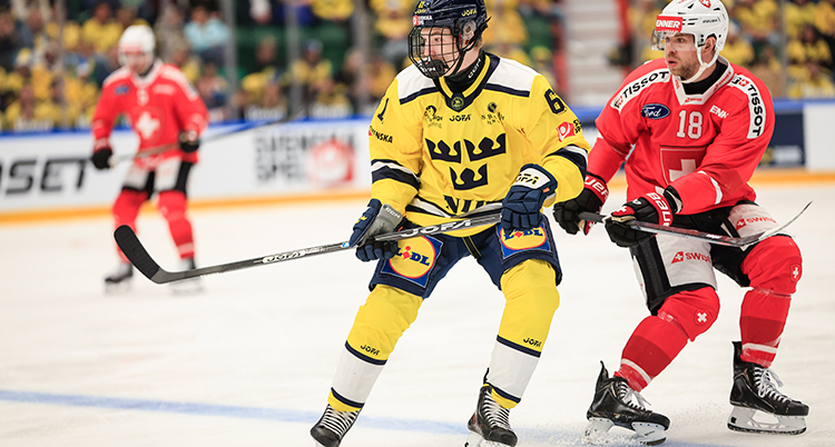 Han spelar ishockey. Flera spelare är på isen.
