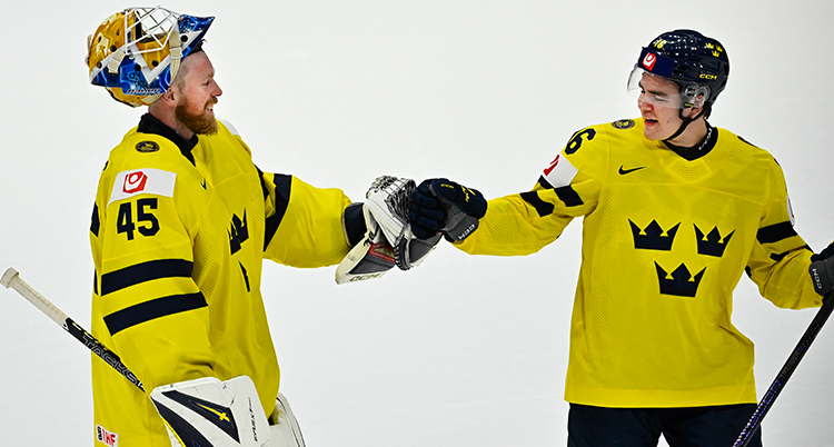 De har gula matchtröjor och hjälmar. De tackar varandra med ena handen.