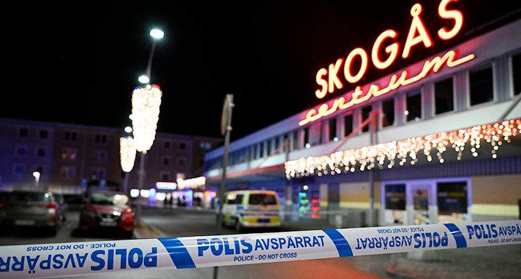 Det är mörkt. Poliserna har spärrat av i Skogås centrum.