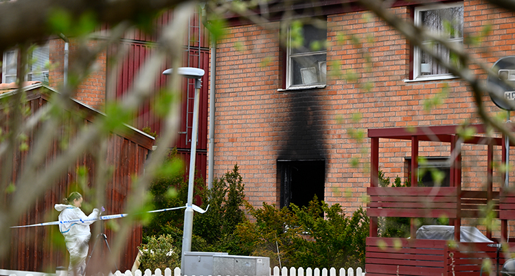 Husets vägg är svart efter eld.