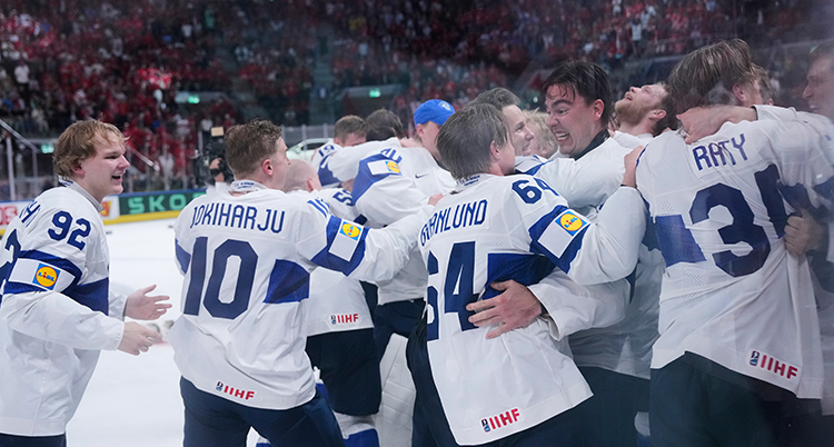 En grupp glada spelare kramar om varandra.