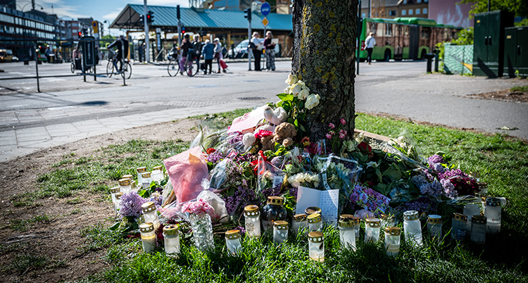 Blommor och ljus vid platsen för olyckan.