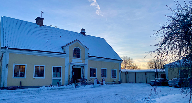 Ett stort hus. Det är snö på taket och på marken.