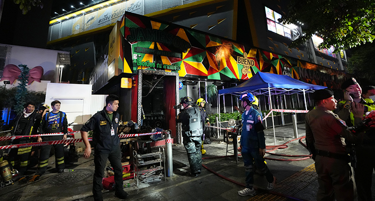 Det är natt i Bangkok. Poliser och räddningsmän står utanför en krog där det har brunnit.