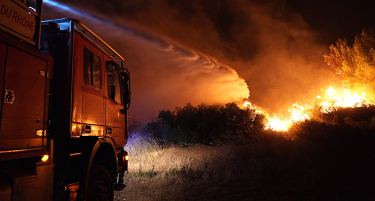 En brandbil försöker släcka en stor brand.