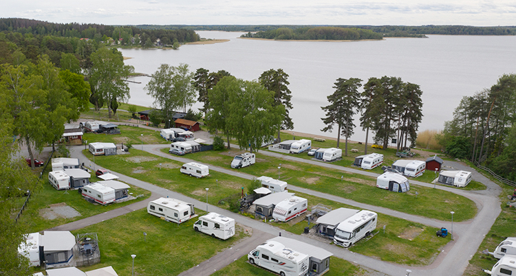 En bild tagen från luften. Nedan syns en campingplats som ligger vid en sjö.