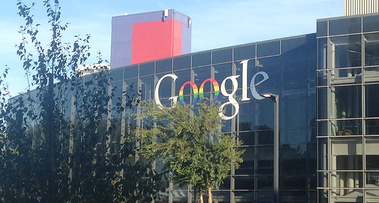 Ett stort hus med mycket glas som det står Google på.