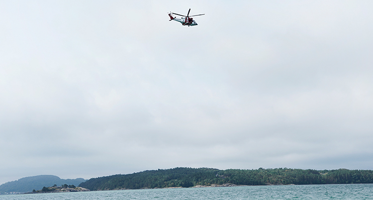 En helikopter över havet. I bakgrunden syns kusten.