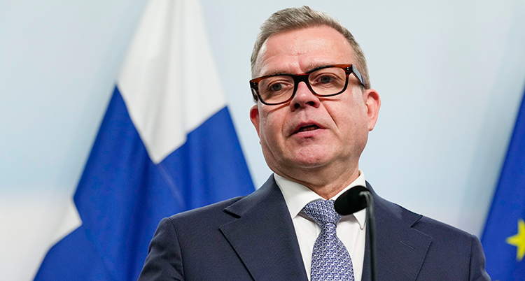 Ett porträtt med Finlands flagga i bakgrunden.