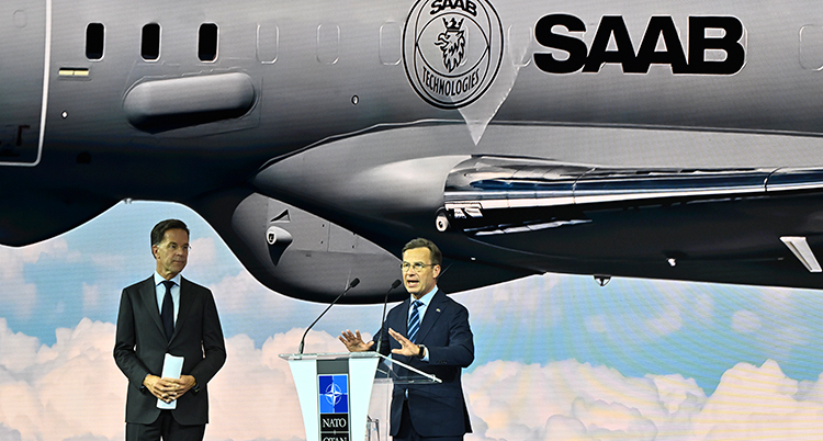 Mark Rutte och Ulf Kristersson pratar framför ett stort flygplan som det står Saab på.