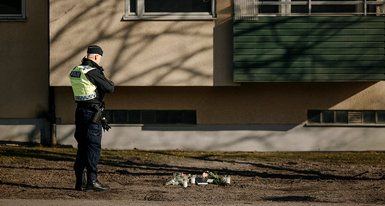 En polis vid platsen för skjutningen.