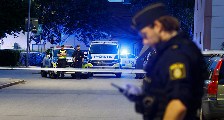 Det är mörkt ute i Uppsala. Poliser och polisbilar är på en gata.